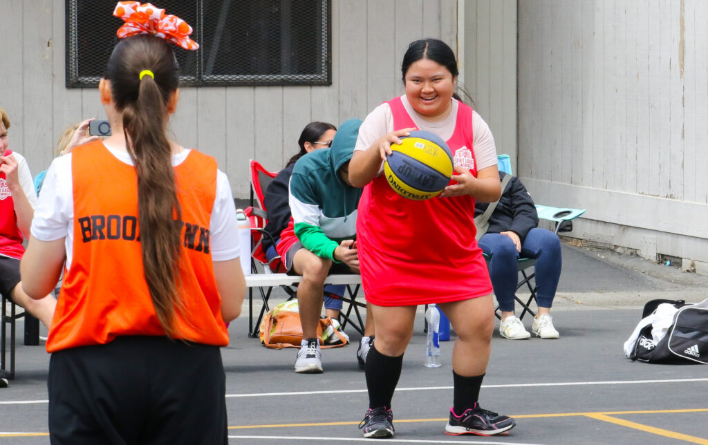 two girls playing coed team basketball